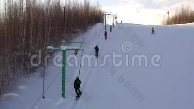 滑雪板在明亮的冬日升起。 滑雪者和滑雪者使用滑雪电梯爬山
